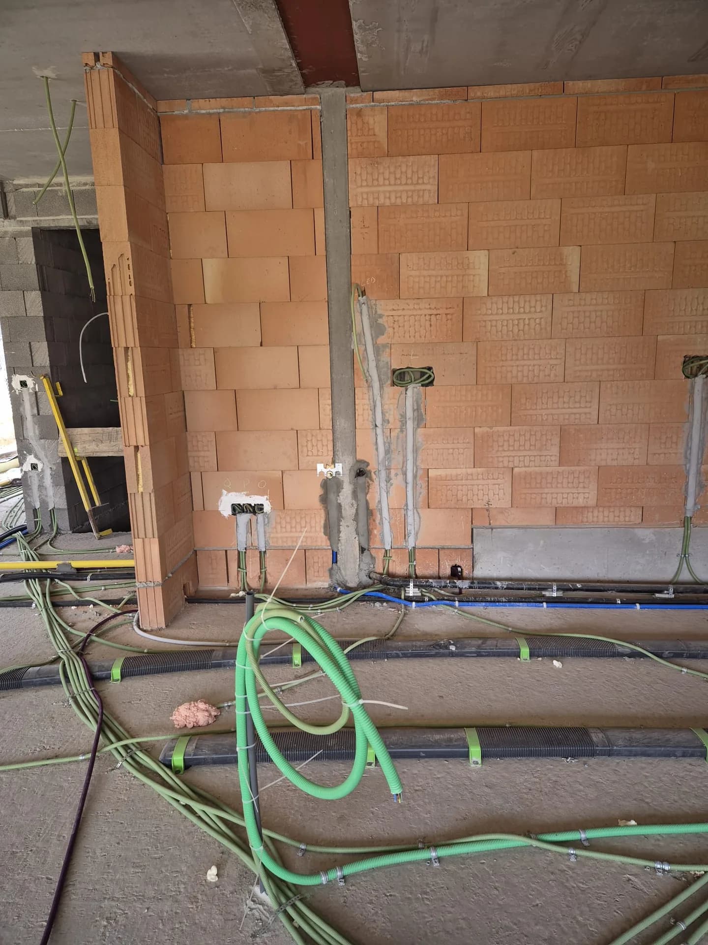 Mur en blocs Porotherm : saignées rebouchées après pose des gaines et des boîtiers d'encastrement.